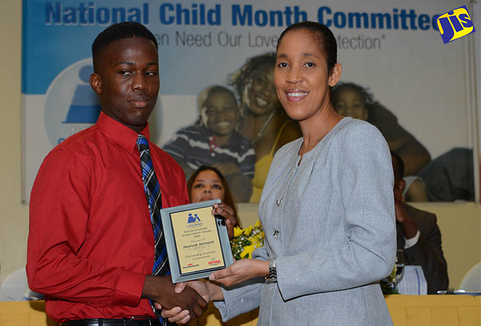 Chief Executive Officer of the Jamaica Information Service (JIS), Donna Marie Rowe (right) presents a plaque to Shamar Bennett, student at the Salvation Army School for the Blind and Visually Impaired in Kingston. The occasion was the National Child Month Committee’s 2016 Youth Academic Achievement Award ceremony held on June 22 at the Knutsford Court Hotel in New Kingston.