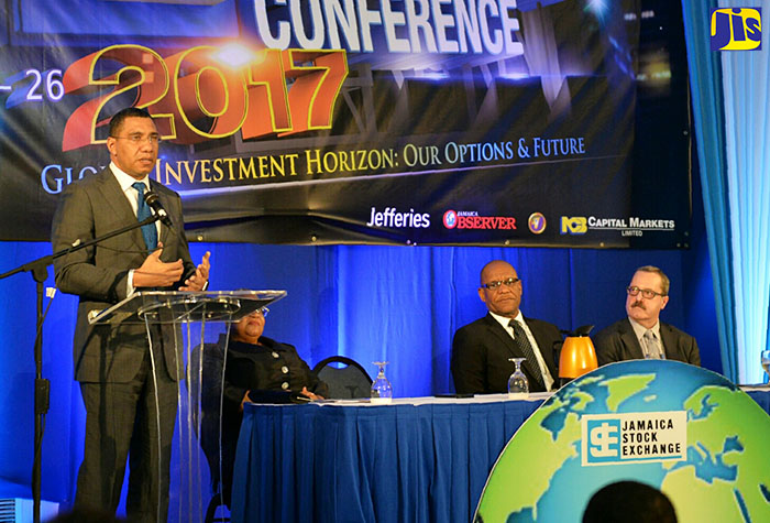Prime Minister, the Most Hon. Andrew Holness (left), addresses the opening ceremony for the Jamaica Stock Exchange (JSE) 12th Regional Investments and Capital Markets Seminar at The Jamaica Pegasus hotel in New Kingston on January 24. Seated (from left) are: JSE General Manager, Marlene Street Forrest; Chairman, Ian McNaughton; and Managing Director of the United States investment firm, Jefferies, Gregory Fisher.
 
