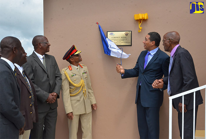 Prime Minister, the Most Hon. Andrew Holness (second right), unveils plaque to mark the renovation of the Curphey Home in Newport, Manchester, on April 19. Others (from left) are Lieutenant Colonel Andrew Sewell; Former Jamaica Teachers