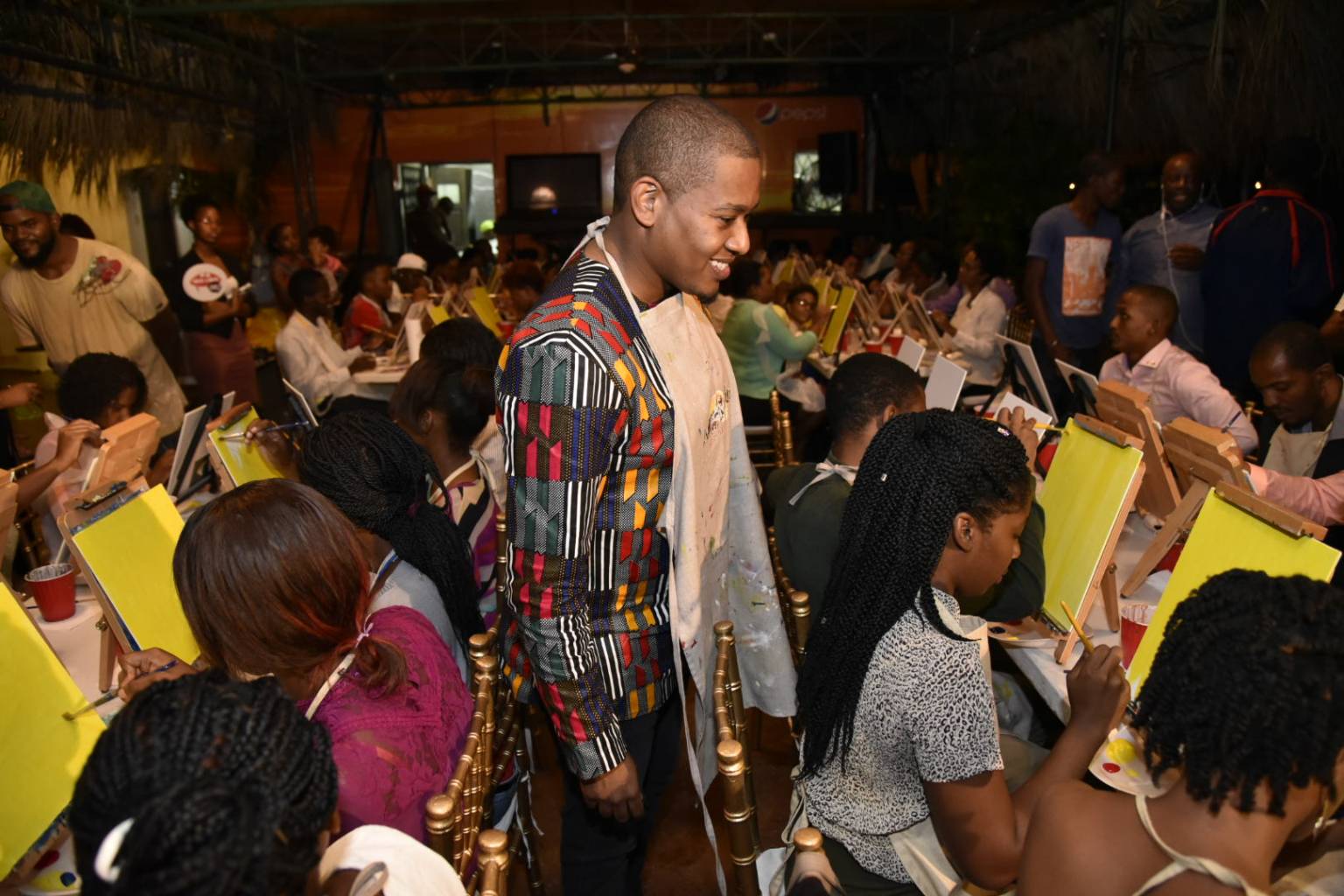 State Minister in the Ministry of Education, Youth and Information, the Hon. Floyd Green, observes young people creating works of art at the launch of Youth Month on Thursday, October 26 at the Serengeti, Hope Zoo in St. Andrew.