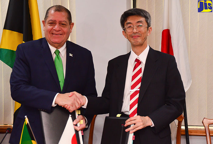 Minister of Finance and the Public Service, Hon. Audley Shaw (left); and Senior Vice President, Japan International Cooperation Agency (JICA), Shigeru Maeda, exchanging copies of the co-financing loan contract for the Energy Management and Efficiency Programme (EMEP), which they signed on Thursday, (November 23) in the Executive Conference Room at the Ministry of Finance and the Public Service, Kingston. 