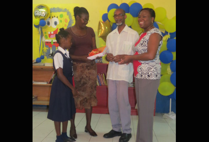 Grade Four student Janelle Dolphy of Allman Town Primary witnesses the purchase of her textbooks by mother Hortense Dolphy from Carlton Allen of Book Express. He recently delivered books ordered by the school to Principal Candi-Lee Crooks-Smith. The cost of the set of Grade Four books was a little over $6000.