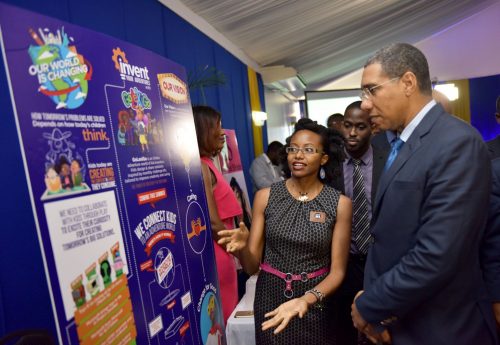 Prime Minister, the Most Hon. Andrew Holness (right), views displays at the booth of business entity, ListenMi Caribbean Limited, being shown to him by Chief Executive Officer, Kenia Mattis (left), during Friday’s (April 27) closing ceremony for the Development Bank of Jamaica (DBJ) Innovation Grant from New Ideas to Entrepreneurship (IGNITE). ListenMi Caribbean was one of the 27 entities benefitting from grants and support services under IGNITE’s 18-month pilot. Looking on is DBJ’s Strategic Services General Manager, Christopher Brown