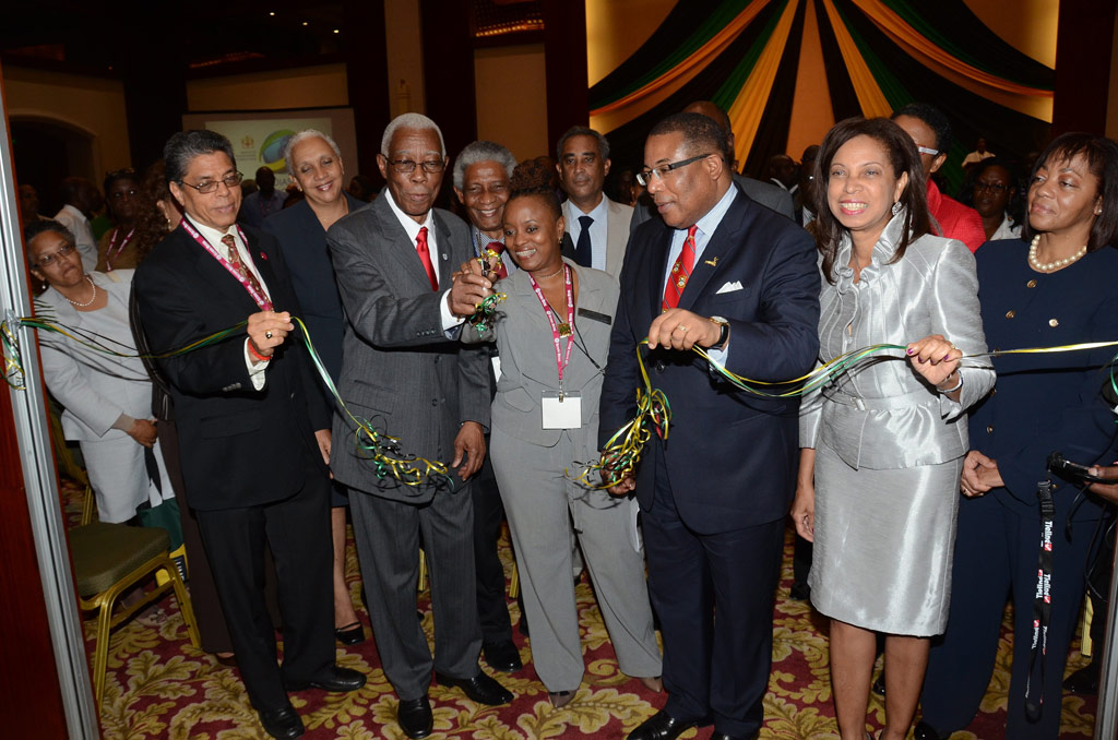 Minister of Foreign Affairs and Foreign Trade, Senator  the Hon. A.J. Nicholson (2nd left), cuts the ribbon to open the Diaspora  Marketplace, a new feature at the 5th Biennial Jamaica Diaspora Conference 2013, which is currently underway at the Montego Bay Convention Centre in St. James.  Assisting Senator Nicholson (from right) are: State Minister in the Ministry of Industry, Investment and Commerce, Hon. Sharon Ffolkes Abrahams;  Minister of Industry, Investment and Commerce, Hon Anthony Hylton; Conference Co-ordinator, Lisa O’Gilvie and Chairman of the Jamaica Diaspora Conference Preparatory Committee, Mr. Richard Powell.
