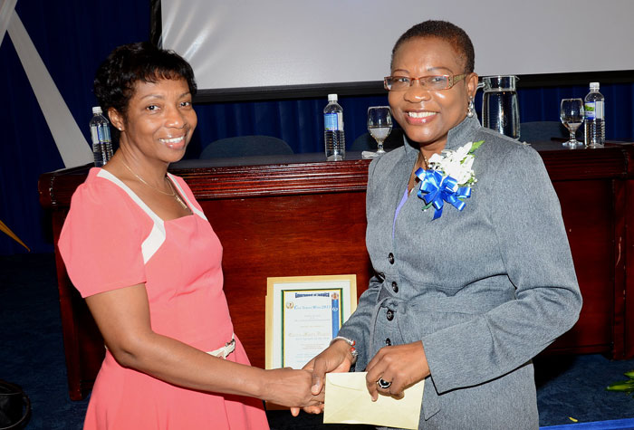 Civil Servant of the Year 2013, Ms. Enthrose Campbell (right), of the Jamaica Information Service (JIS), is greeted  by her predecessor, Beverley Davis Samuels (left).  Ms. Campbell was named Civil Servant of the Year  at the official launch of Civil Service Week , held on November 15,  at the Bank of Jamaica Auditorium in Kingston. The week is being celebrated under the theme: ‘Transformation and Renewal for a Better Tomorrow’.