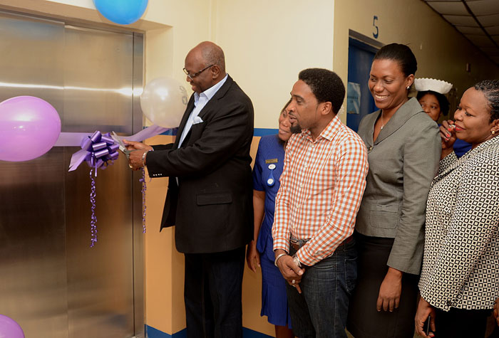 Minister of Health, Hon. Dr. Fenton Ferguson (left), cuts the ribbon to commission into service one of two new elevators at the Kingston Public Hospital (KPH) on July 10. Others (from 2nd left) are: Director of Nursing Services at the KPH, Joan Walker-Nicholson; Chairman of the South East Regional Health Authority (SERHA), Dr. Andrei Cooke; Senior Medical Officer at KPH, Dr. Natalie Whylie; and Regional Director at SERHA, Maureen Golding.