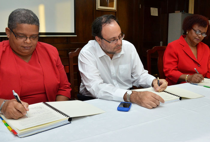 Minister of Justice, Senator the Hon. Mark Golding; and  Permanent Secretary in the Ministry, Carol Palmer (left); participate in the signing of a contract for Phase 11 of the Justice Square Project,  with Managing Director for MLO Construction, Melanie Fisher. The signing took place at the Ministry of Justice on December 3.