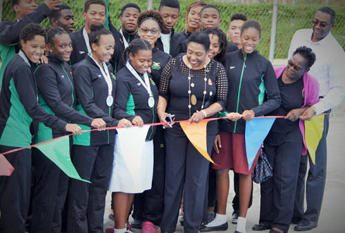 The Honourable Olivia Grange, Minister of Culture, Gender, Entertainment and Sport, cuts the ribbon to signal the official reopening of the diving pool at the National Aquatics Centre yesterday May 18. Members of the National Water Polo team and President of the Amateur Swimming Association of Jamaica, Handel Lamey are also photographed.