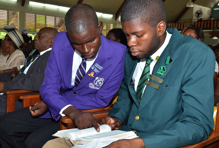 Kingston College Senior Prefect, Demaye Whitely (left), and  Calabar High School Deputy Head Boy, Shashawny Smith, share a bible during a church service held on Sunday, November 10, at the Boulevard Baptist Church in Kingston. The service was to celebrate the covenant relationship between the Parent-Teacher Associations (PTA) of the two institutions. 