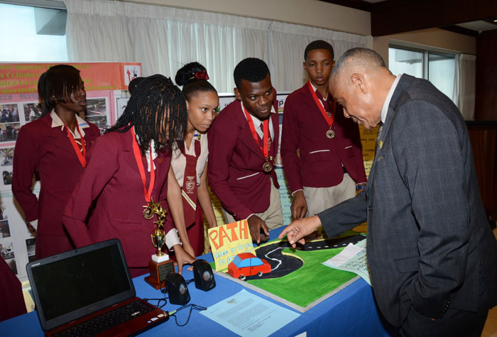 Minister of Labour and Social Security, Hon. Derrick Kellier (right) engages students of Godfrey Stewart High School in Westmoreland during the inaugural staging of the Jamaica Productivity Centre’s (JPC) Secondary Schools’ Productivity Improvement Project at the Jamaica Pegasus Hotel in Kingston today (May 7). The institution won third place in the competition. Their project focused creating a more structured environment for by PATH students during the lunch break at their school. The Secondary Schools’ Productivity Improvement Project aimed to expose students to the concept of continuous improvement, in an effort to raise their level of understanding of productivity. The programme taught students and teachers about the concept of continuous improvement and allowed them to apply it to their school environment over 11 weeks. 