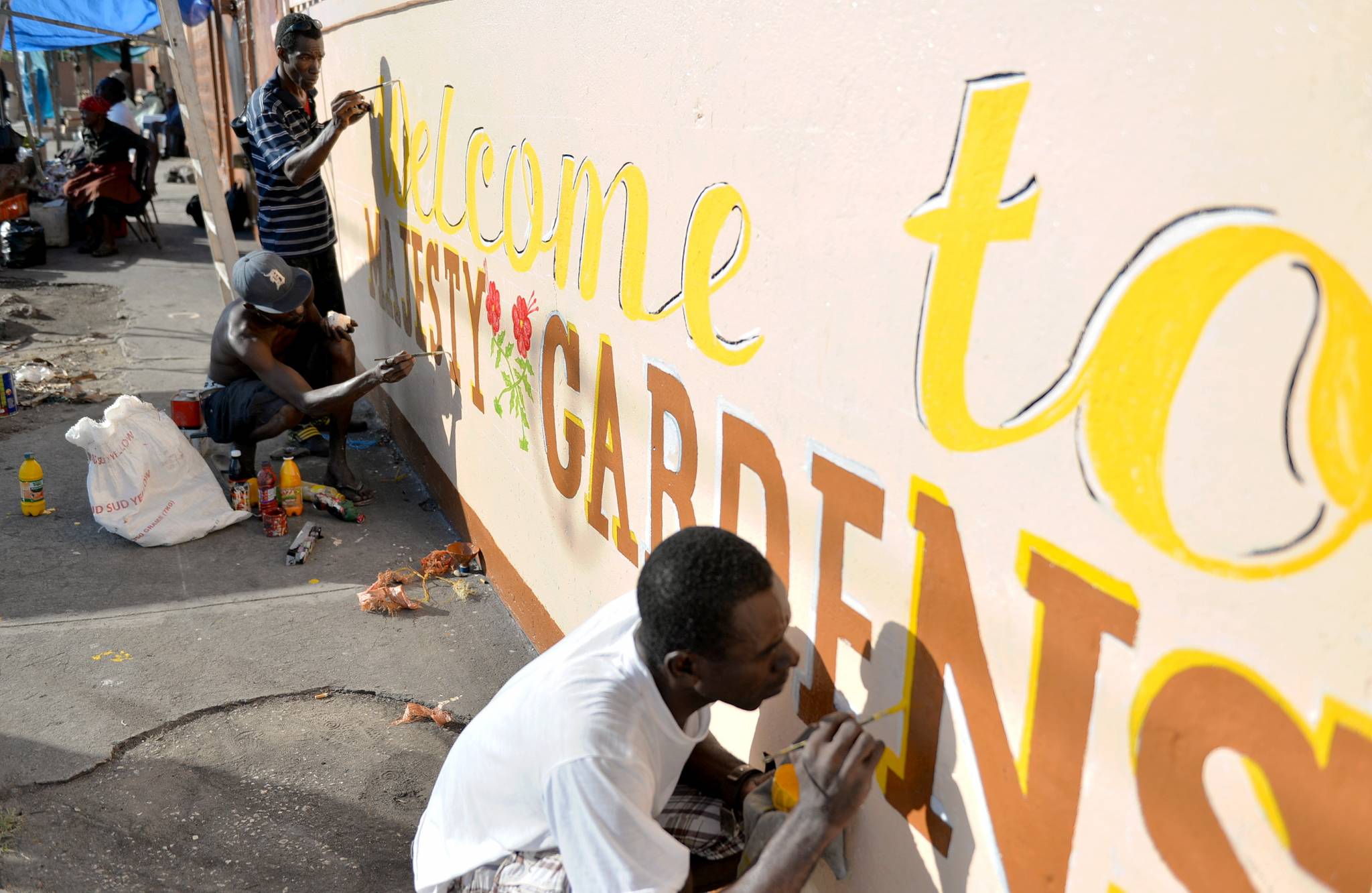 Community members of Majesty Gardens paint a welcoming sign, as they take part Labour Day activities to beautify their community, today (May 23). Labour Day, which concludes Workers’ Week, is being celebrated under the theme: ‘Take a Stand…Beautify our Land’.
