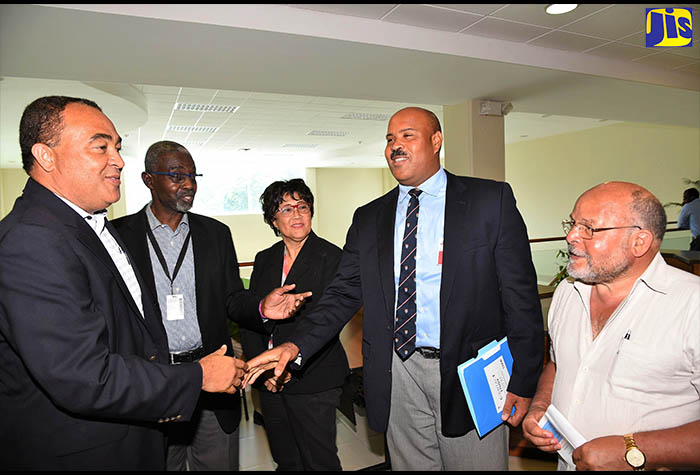 Minister of Health, Dr. the Hon.  Christopher Tufton (left), is greeted by  Director of the University of the West Indies (UWI) Epidemiology Unit, Professor Marshall Tulloch-Reid (4th left), at a forum organised by the Caribbean Institute for Health Research (CAIHR),  today (July 6), at the UWI Mona Campus, in St. Andrew. Others (from left) are Co-Investigator at the Unit, Professor Rainford Wilks; Advisor on Health System and Services at the Pan American Health Organization (PAHO), Dr. Hedwig Goede, and retired UWI Professor, Alan Jackson.