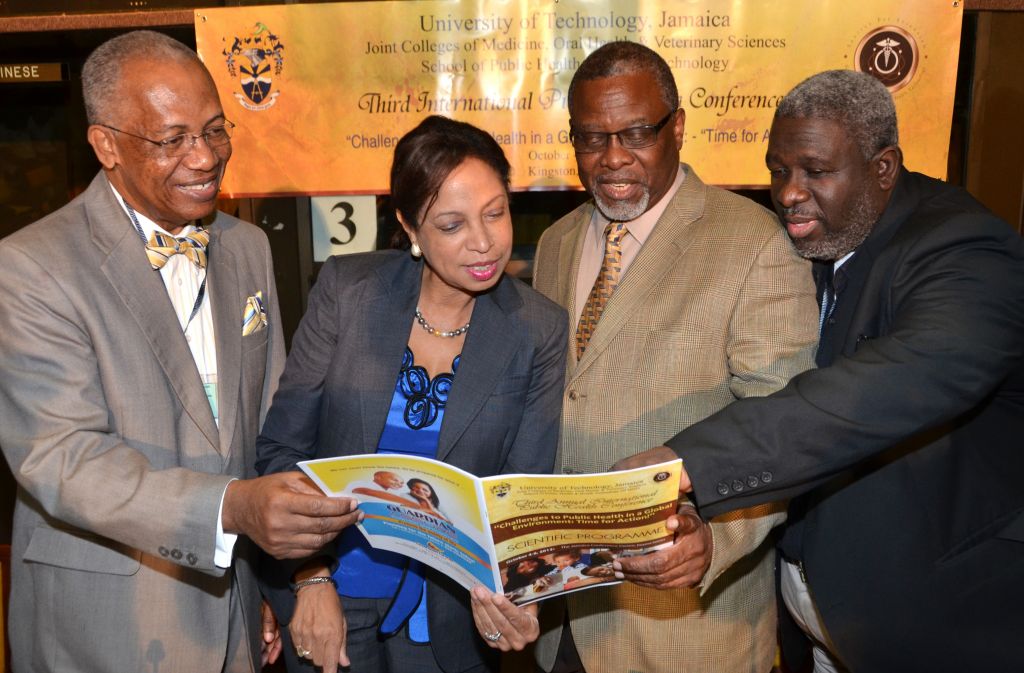 Minister of State in the Ministry of Industry, Investment and Commerce, Hon. Sharon Ffolkes-Abrahams (second left), examines contents of the programme during the opening ceremony for the third annual international public health conference at the Jamaica Conference Centre in downtown Kingston, today (October  4). Others (from left) are: Head, School of Public Health and Health Technology, University of Technology (UTech), Professor  Winston Davidson; Acting President, UTech, Dr. Kofi Nkrumah Young; and Dean, Joint Colleges of Medicine, Oral Sciences and Veterinary Sciences, UTech,  Dr. Irving McKenzie. The conference, which is slated to end on October 6, is being held under the theme: ‘Challenges to Public Health in a Global Environment: Time for Action’. It is being staged by the University of Technology, Joint Colleges of Medicine, Oral Health and Veterinary Sciences, and School of Public Health and Health Technology (SPHHT).