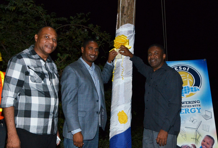 Minister of Science, Technology, Energy and Mining, Hon. Phillip Paulwell (right), is joined by People’s National Party (PNP) candidate for the February 25 General Elections for South West St. Elizabeth, Hugh Buchanan (centre) and Chairman of National Energy Solutions (NESol), Garfield Daley, to officially commission into service electricity supply for 29 houses in Gillard in South West St. Elizabeth,  on February 16.
