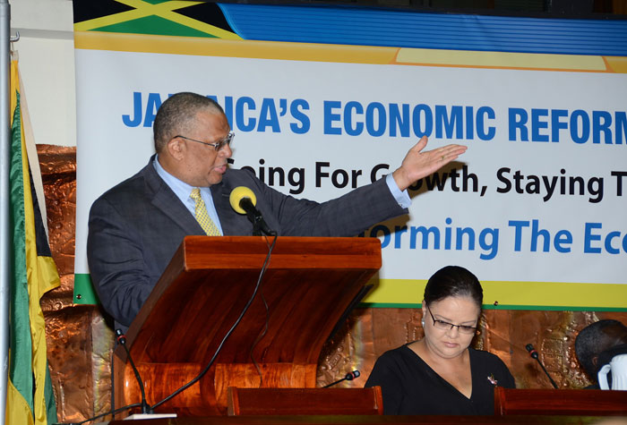 Finance and Planning Minister, Dr. the Hon. Peter Phillips (at podium), emphasizes a point while addressing Thursday’s (Sept. 12), Economic Reform Programme (ERP) stakeholders conference, hosted by the Ministry at the Jamaica Conference Centre, downtown Kingston, under the theme: “Jamaica’s Economic Programme – Going for Growth, Staying the Course, Transforming the Economy”. Also pictured is: Minister with Responsibility for Information, Senator the Hon. Sandrea Falconer (left, seated).