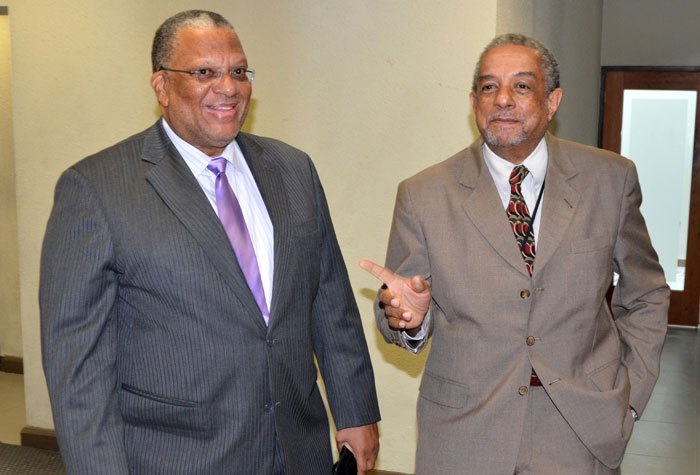 Finance and Planning Minister, Dr. the Hon. Peter Phillips (left), converses with by Planning Institute of Jamaica (PIOJ) Director General, Colin Bullock, prior to the start  of Wednesday’s (July 16) launch of the Government of Jamaica’s Social Protection Strategy at the PIOJ’s New Kingston offices. Dr. Phillips was the keynote speaker.