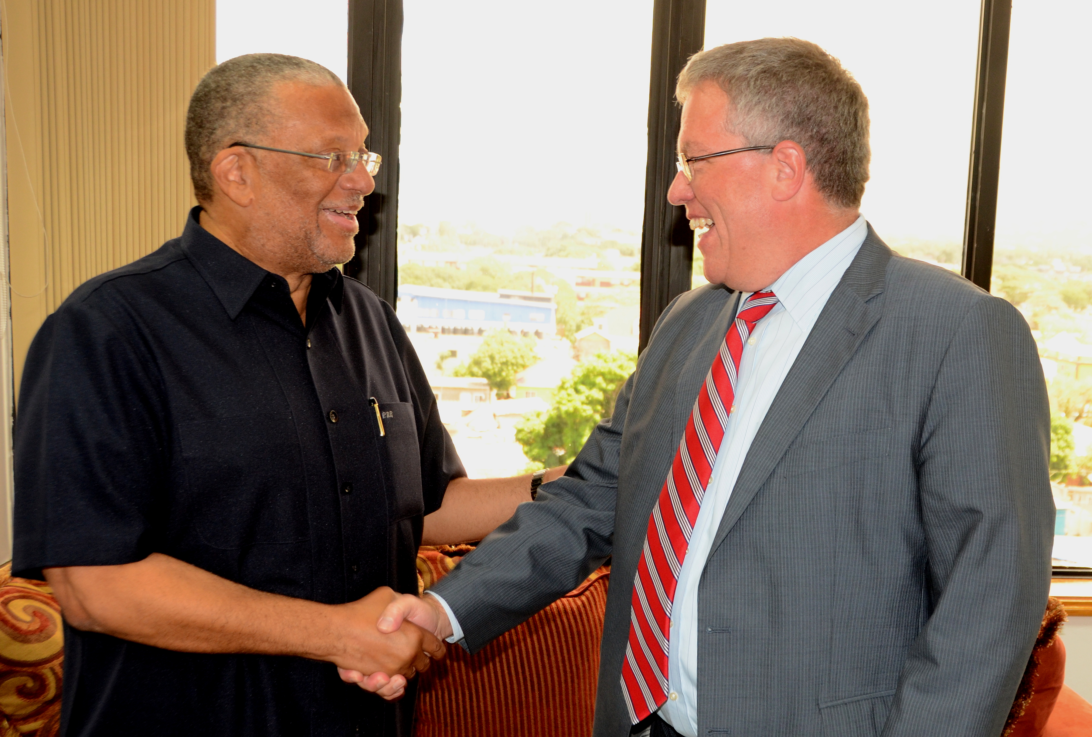 Minister of Finance and Planning, Dr. the Hon. Peter Phillips (left), greets outgoing Canadian High Commissioner to Jamaica, His Excellency Robert Ready, when he called on the Minister to say farewell,  at his National Heroes Circle offices, in Kingston, on August 14.