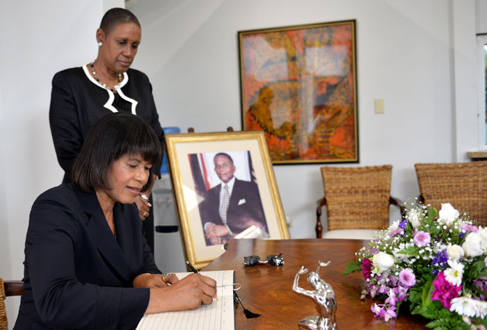 Prime Minister Portia Simpson Miller signs the condolence book for the late former Prime Minister and President of the Republic of Trinidad and Tobago, the Honourable Arthur ‘ANR’ Robinson who passed away on Wednesday, April 9. The Prime Minister visited the High Commission Office in Kingston on Monday, April 14 to pay her respects to the former Prime Minister and President. Looking on is Dr. Iva Gloudon, Trinidad and Tobago High Commissioner to Jamaica. Prime Minister Simpson Miller said “Trinidad and Tobago has lost a giant of a human being, a distinguished leader and Statesman, and the Caribbean, a true son of our regional community.” Mrs. Simpson Miller described ANR Robinson as one of the Caribbean’s most accomplished leaders who fought vigorously and advocated strongly for the sovereign rights of his countrymen and the Caribbean people and his stewardship and leadership roles contributed significantly to the Caribbean integration movement. 
