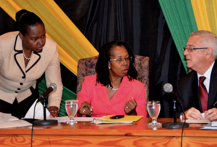 Education Minister, Hon. Rev. Ronald Thwaites (right), consults with Permanent Secretary in the Ministry, Elaine Foster Allen (centre); and Chief Education Officer in the Ministry, Grace McLean, during a back to school press conference at the Office of the Prime Minister in Kingston, on August 23.
