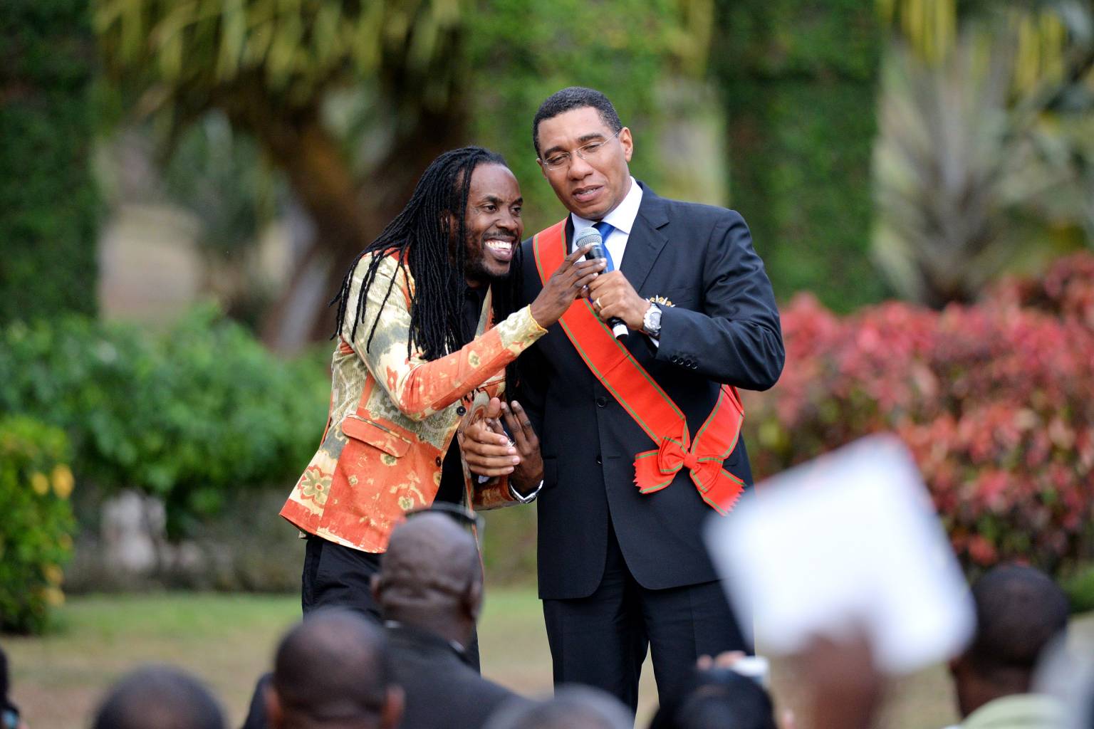 Prime Minister, the Most Hon. Andrew Holness shares the stage with Reggae singer, Nesbeth during Thursday, March 3, swearing in ceremony at King's House. 