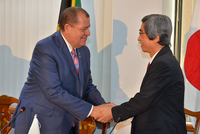 Finance and the Public Service Minister, Hon. Audley Shaw (left), greets Japan’s Ambassador to Jamaica, Ambassador Masanori Nakano, during Wednesday’s (April 12), signing ceremony for the implementation of a $348.9 million (¥300 million/US$2.7 million) grant-funded three-year ‘Project to Promote Energy Efficiency in Caribbean Countries’ at the Ministry’s offices in Kingston.