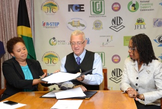 Minister of Education, Hon. Rev. Ronald Thwaites (centre), accepts a signed agreement from Country Manager, Microsoft Jamaica Inc., Marcelle Smart (left), which will see the computer software company providing training, technical support and access to technology for Jamaica’s teachers and students. Looking on at right is Permanent Secretary in the Ministry, Elaine Foster Allen. The signing took place on July 31, at the Ministry’s National Heroes Circle offices in Kingston.