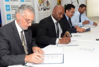 It was serious business as (from left) Mr. Russell Hadeed, Chairman, Petroleum Corporation of Jamaica (PCJ), Dr. Andrew Wheatley, Minister of Science, Energy and Technology, Professor Stephen Vasciannie, President, University of Technology, Jamaica and Mr. Winston Watson, Group General Manager, PCJ signed a partnership agreement to establish the PCJ Renewable Energy Scholarship and a grant which will provide funding for research projects to be undertaken by students at UTech’s School of Engineering.  Under the agreement, which was signed today, (Wednesday March 15) at the PCJ Resource Centre in New Kingston, the PCJ will provide up to $5 million to finance the research grant and the Scholarship. 