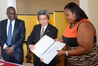 Education, Youth and Information Minister, Senator the Hon. Ruel Reid (left), looks on as Japan’s Ambassador to Jamaica, His Excellency, Masanori Nakano (centre), and Warsop Primary School Principal, Stephanie Codling-Smith, display the signed agreement for a $10. 2 million grant to undertake upgrading works at the school. The grant signing and handing over ceremony was held at the Ambassador’s residence in St. Andrew on March 24. 