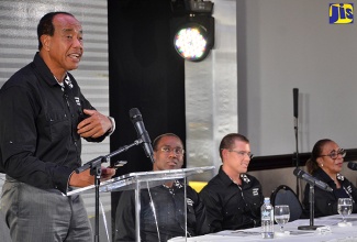 Economic Growth Council (EGC) Chairman, Michael Lee-Chin (left), addresses Thursday’s (January 26) quarterly media briefing at The Jamaica Pegasus hotel in New Kingston.  Seated (from left) are EGC Deputy Chairman, Ambassador Nigel Clarke; and members, Adam Stewart and Pat Ramsay.