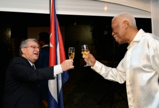 Minister of Foreign Affairs and Foreign Trade, Senator the Hon. A. J. Nicholson (right), raises a toast to Cuba’s Ambassador to Jamaica, His Excellency  Bernardo Guanche Hernandez (left), at a reception held at the Ambassador’s residence in St. Andrew on Thursday (Jan 22), to mark the 56th anniversary of the Triumph of the Cuban Revolution (National Day).