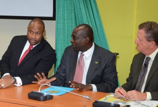 Minister of Education, Youth and Information, Senator the Hon. Ruel Reid (centre), converses with Permanent Secretary in the Ministry, Dr. Maurice Smith (left),  at the official launch of the Alternative Pathways to Secondary Education (APSE),  held on March 23, at the Regional headquarters of the University of the West Indies, Mona.  At right is international education expert, Dr. Richard Villa.