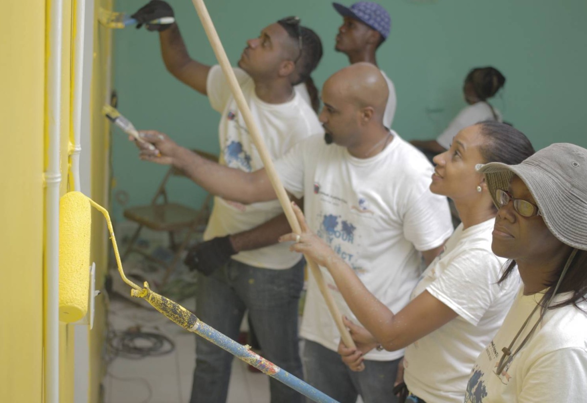 General Manager at Monumental Partners, Christopher Goulbourne (left), leads in painting the classrooms at the Abilities Foundation, in St. Andrew, yesterday (May 23). The group partnered with World Brands Services to give the institution a facelift as their Labour Day project. Others  (from second left) are: Director, Monumental Partners, Kahlil Harris; Marketing Executive at World Brands Services,Tania Christie, and Managing Director at the Foundation, Susanne Hamilton.