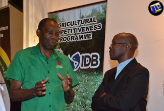 Minister without Portfolio in  the Ministry of Industry, Commerce, Agriculture and Fisheries, Hon. J.C. Hutchinson (left), speaking with  Agribusiness Specialist, Ainsworth Riley, at the opening of a two-day seminar on Farm Enterprise Management at the Hyatt Ziva/Zilara Hotel, Montego Bay, St. James, on August 29.