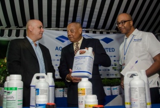 Minister of Agriculture and Fisheries, Hon. Derrick Kellier (centre), speaks with Chairman, Ag-Chem Plant Limited (ACP), Joe Pires Jr (left) about insecticides manufactured  by the company. Occasion was the official launch of ACP on January 26 at the Terra Nova All-Suite hotel in St. Andrew. Also pictured is General Manager, ACP, Graham Dunkley. 