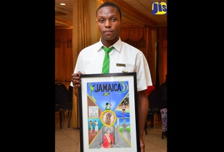 Winner in the poster segment of the Jamaica Information Service (JIS) Heritage Competition for 2017, Akeem Plummer, shows off his winning the poster. 