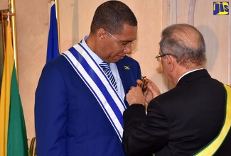 Prime Minister, the Most Hon. Andrew Holness (left), is conferred with the Order of Merit of Duarte, Sánchez and Mella in the rank of Grand Cross with Gold Breast Star by President of the Dominican Republic, His Excellency Danilo Medina Sánchez, during a State Luncheon at King’s House today (November 27).