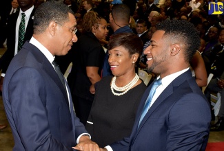 Prime Minister the Most Hon. Andrew Holness (left), offers words of comfort to Margaret Boyne (centre), widow of late Jamaica Information Service Deputy Chief Executive Officer and Chief State Liaison, Ian Boyne, and son, Andre, during Sunday’s (January 14,) Thanksgiving Service at the National Indoor Sports Centre in Kingston.