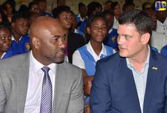 Minister of Science, Energy and Technology, Dr. the Hon. Andrew Wheatley (left) speaks with President and Chief Executive Officer (CEO) of the Jamaica Public Service (JPS), Emanuel DaRosa during a ceremony for the re-launch of the JPS Foundation Energy Club at the Merl Grove High School in Kingston on Wednesday (March 7). 
