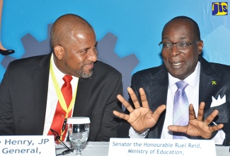 Minister of Education, Youth and Information, Senator the Hon. Ruel Reid (right), makes a point to Director General, Planning Institute of Jamaica (PIOJ), Dr. Wayne Henry, at the opening of a Labour Market Forum at the Spanish Court Hotel in St. Andrew today (February 14). The two-day event is being hosted by the PIOJ in collaboration with the Inter-American Development Bank (IDB) and the HEART Trust/NTA.