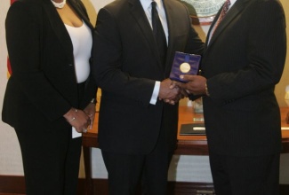 Montego Bay’s Mayor, Councillor Glendon Harris (right), receives a token from Atlanta’s Mayor, Kasim Reid, after discussions on various topics relating to both cities at Atlanta City Hall, downtown Atlanta on Tuesday (May 21). Sharing in the occasion is Chairman of the St. James Parish Council Civic and Community Affairs Committee, Councillor Suzette Brown. Photo: Derrick A Scott