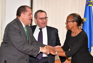 Finance and the Public Service Minister, Hon Audley Shaw (left), greets Inter-American Development Bank (IDB) General Manager, Country Department, Caribbean Group, Therese Turner-Jones, during Thursday’s (February 1) signing ceremony for €9.17 million (US$10 million) in grant funding under the European Union-Caribbean Investment Facility (EU-CIF) for the Government’s energy management and efficiency project.  The signing took place at the  Ministry in  Kingston. At centre is Director-General for International Cooperation and Development in the European Commission, Stefano Manservisi.