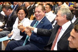 Minister of Industry, Commerce, Agriculture and Fisheries, Hon. Audley Shaw (centre), congratulates President, Jamaica Exporters’ Association (JEA), Michelle Chong,  and President, Jamaica Manufacturers’ Association (JMA), Metry Seaga, following the announcement that the JEA and the JMA have merged. Occasion was the opening ceremony for Expo Jamaica 2018 at the National Indoor Sports Centre on April 19. At left is Minister without Portfolio in the Ministry of Economic Growth and Job Creation, Daryl Vaz, and at right is Chief Executive Officer, Digicel Jamaica, Justin Morin. Expo Jamaica 2018 is being held under the theme: ‘Advancing Breakthroughs’.

