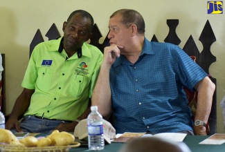 Minister of Industry, Commerce, Agriculture and Fisheries, Hon. Audley Shaw (right), speaking with State Minister, Hon. J.C. Hutchinson, at the Rural Agricultural Development Authority’s Sensitisation Meeting and National Irish Potato Stakeholders Seminar held in Devon, Manchester, on Thursday (April 26).