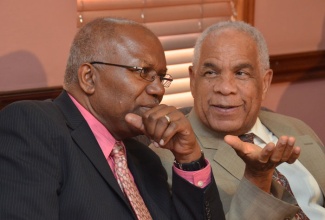 Minister of Transport, Works and Housing, Dr. the Hon. Omar Davies (right), having a light discussion with Minister without Portfolio in the Ministry, Hon. Dr. Morais Guy, at a press conference to announce a new fare structure for the JUTC as well as operators within the transport sector. The press briefing was held on Monday, August 19, at the Ministry’s Maxfield Avenue offices.
