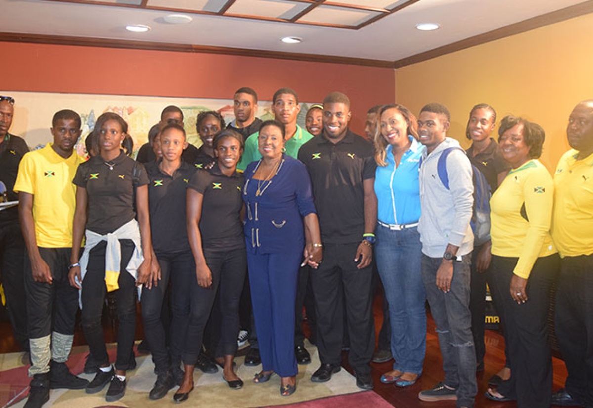 Minister of Culture, Gender, Entertainment and Sport, the Honourable Olivia ‘Babsy’ Grange with members of the track and field team that represented Jamaica at the recently concluded 45th CARIFTA Championships held in Grenada, following their arrival at the Norman Manley International Airport in Kingston on Tuesday, March 29, 2016. 