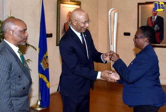 Governor-General, His Excellency the Most Hon. Sir Patrick Allen (2nd left), is presented with the Queen’s Baton by Honorary Legal Advisor to the Commonwealth Games Federation, Sandra Osbourne (right), at King’s House on July 5. Looking on is President of the Jamaica Olympic Association (JOA), Christopher Samuda. The Queen’s Baton is making a seven-day stop in Jamaica as part of a global journey ahead of the Commonwealth Games in Gold Coast, Australia, in April 2018. 