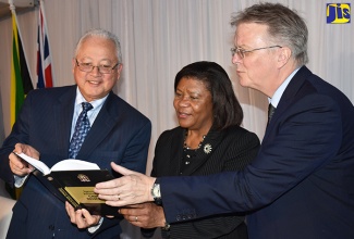 Minister of Justice, Hon. Delroy Chuck (left), along with Chief Justice, Hon. Zaila McCalla (centre), and British High Commissioner to Jamaica, His Excellency, David Fitton (right), peruse the newly published Criminal Bench Book, developed by the Government of Jamaica in collaboration with the United Kingdom Government. Occasion was the launch of the publication on March 17 at The Spanish Court Hotel in New Kingston.