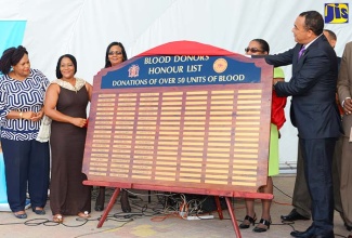 Minister of Health, Dr. the Hon Christopher Tufton (right), is assisted in unveiling the Blood Donors Honour List by Jamaica’s Champion Blood Donor, Sonya Binns-Lawrence (2nd left),  at the opening ceremony of World Blood Donor Day 2016. The event was held at Emancipation Park on June 14, 2016. The Honour List recognises blood donors who have given more than 50 units of blood. Also participating in the event are (from left) Pan American Health Organization (PAHO)/World Health Organization (WHO) Country Representative in Jamaica, Dr. Noreen Jack; Director of the National Blood Transfusion Service, Dr. Veronica Taylor; and Director, National Laboratory Services, Dr. Angela Scott.  