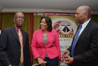 Minister without Portfolio in the Ministry of Transport, Works and Housing, Hon. Dr. Morais Guy (right), is in light discussion with Vice Chairman/Convenor, National Road Safety Council (NRSC), Dr. Lucien Jones (left) and Executive Director, NRSC, Paula Fletcher during the Council’s poster competition awards ceremony, held today (July 11) at the Knutsford Court Hotel in New Kingston.