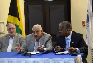 Minister of Transport and Mining, Hon. Mike Henry, addresses the 18th Meeting of the Caribbean Aviation Safety and Security Oversight System (CASSOS) Board of Directors at the Jamaica Pegasus Hotel on June 1. At right is Chairman of CASSOS and Director General of the Jamaica Civil Aviation Authority, Mr. Nari Williams Singh and at left is the Chairman of the Jamaica Civil Aviation Authority, Mr. Philip Henriquez. 